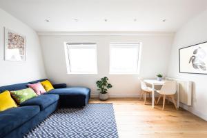 a living room with a blue couch and a table at The Penthouses, 9 Albion Mews in Chester