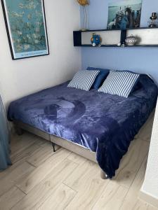 een bed met een blauw dekbed in een slaapkamer bij Appartement F3 avec jolie vue in Le Barcarès