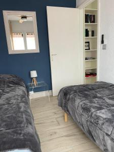 een slaapkamer met 2 bedden en een spiegel bij Appartement F3 avec jolie vue in Le Barcarès