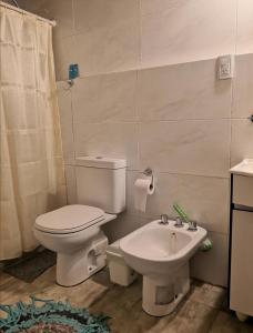 een badkamer met een toilet en een wastafel bij Depto Boutique LA ALDEITA in Sierra de los Padres