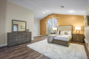 1 dormitorio con cama y espejo grande en Charming 3BR 3Bath In Brilliant Location!, en Monroe