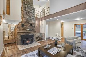 a living room with a stone fireplace at Charming 3BR 3Bath In Brilliant Location! in Monroe