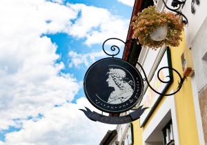 a sign hanging on the side of a building at Mathias Rex in Szentendre