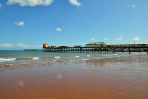 a pier on the beach next to the ocean at Flat by the sea in Paignton