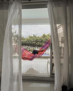 梅爾加的住宿－Hotel Cacique Guaicani，睡在阳台上吊床上的人