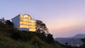 a building on a hill with its lights on at The Summit Kandy in Kandy