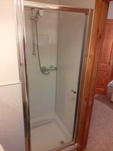 a shower with a glass door in a bathroom at Balinoe Beag, Spean Bridge, Near Fort William in Spean Bridge