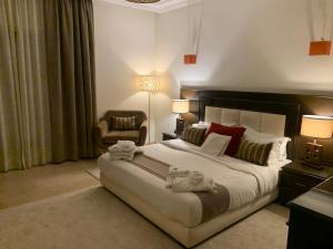 a hotel room with a large bed and a chair at Villa Oree Du Parc in Casablanca