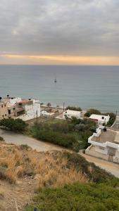 a view of the ocean with a boat in the water at Minoan house in Tsoutsouros
