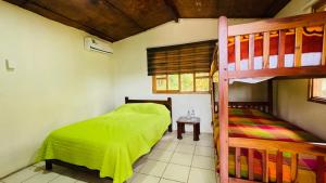 a bedroom with a bunk bed next to a bunk bed gmaxwell gmaxwell gmaxwell at Hostería Kasadasa in Santo Domingo de los Colorados