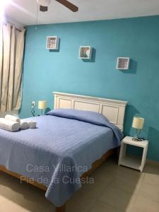 1 dormitorio con 1 cama con pared azul en Hermosa y Amplia Casa en Pie de la Cuesta, en Coyuca