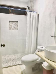 een badkamer met een toilet, een wastafel en een douche bij Hermosa y Amplia Casa en Pie de la Cuesta in Coyuca