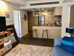 uma sala de estar com um sofá e uma cozinha em Modern Spacious City Pad with Rooftop Pool and Gym em Sidney