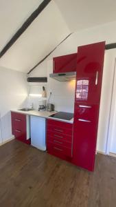een keuken met rode kasten en een rode koelkast bij The Horse Farm in Garnwerd