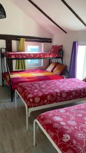 a bedroom with two bunk beds with red sheets at The Horse Farm in Garnwerd