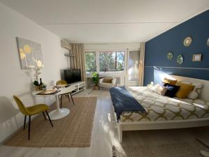 una camera con letto, scrivania e TV di Luganersee, Pool, Strand, Parkplatz, Suite a Bissone