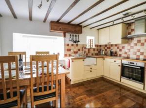 a kitchen with a table and some chairs in it at Church Gate Cottage - Bridestowe in Bridestowe