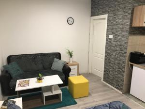 - un salon avec un canapé et une table dans l'établissement Zen Apartmani, à Zrenjanin