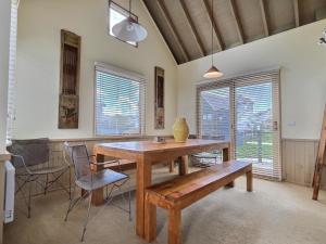 a dining room with a wooden table and a bench at 360 Degrees, alpine-getaways in Dinner Plain +4 photos