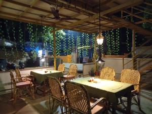 a restaurant with tables and chairs and a large window at Cilantro Agonda in Agonda +44 photos