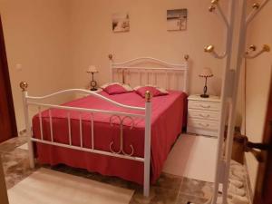 um quarto com uma cama branca e um cobertor vermelho em Altura Beach House em Altura