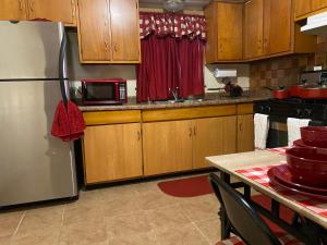 a kitchen with wooden cabinets and a stainless steel refrigerator at Nice 3 Bdr FREE Wine, Wi-fi and Parking in Milwaukee