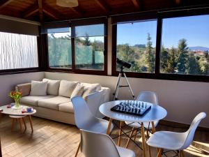 een woonkamer met een bank, een tafel en stoelen bij Zafeiria's Suite in Vamos