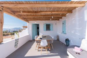 a room with a table and chairs on a balcony at Blue Harpist Villas in Koufonisia