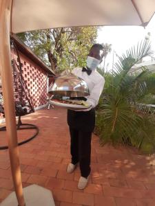 a person wearing a mask holding a tray of food at PolanaHibiscosLodge&Spa in Maputo +49 photos