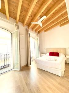 1 dormitorio con cama blanca y techo de madera en Top-notch downtown house with private rooftop terrace and parking opt en Sevilla