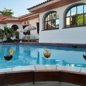 马普托PolanaHibiscosLodge&Spa的一座房子,设有一个游泳池,提供两杯葡萄酒