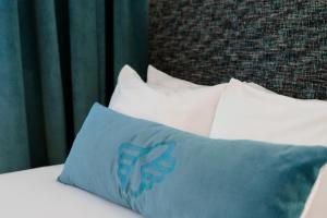 a bed with pillows and pillows on it at The Burrard in Vancouver