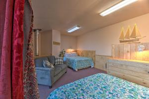 a hotel room with a bed and a couch and a bedroom at Sanderling Sea Cottages, Unit 2 Walk to Coast! in Waldport