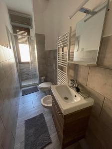 le tre sorelle apartments في Busnago: حمام مع حوض ومرحاض ومرآة