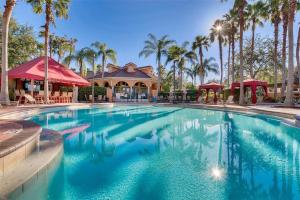 a large swimming pool in front of a building with palm trees at SOLANA 7 Bed Rooms FAMILY VACATION VILLA-Private Pool and SPA in Davenport