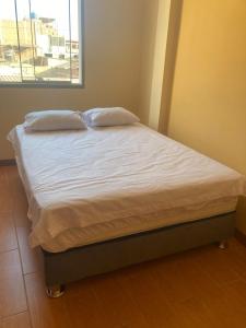 - un lit avec 2 oreillers dans une chambre dans l'établissement Alojamiento en Mancora - Alipio House, à Máncora