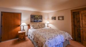 1 dormitorio con 1 cama, 2 lámparas y puerta en Spacious & Cozy Condo With Wood Fireplace condo, en Crested Butte