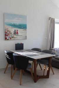 uma mesa de jantar com cadeiras e um quadro na parede em Amazing villa Galeb in Murter em Murter