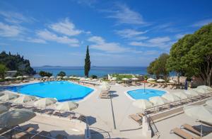 vista sulla piscina in un resort con sedie e ombrelloni di Maistra Select Astarea Hotel a Mlini