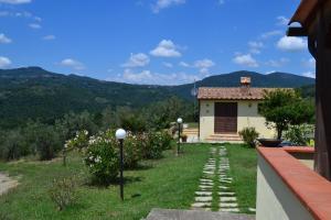 a house with a garden with a view of mountains at Podere dei maddii in Roccastrada