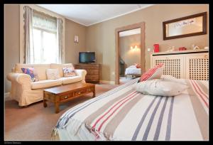 ein Schlafzimmer mit einem Bett und ein Wohnzimmer mit einem Sofa in der Unterkunft Auberge De La Gaichel in Gaichel