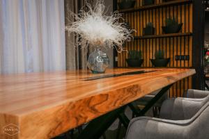 a wooden table with a vase on top of it at Villa Familia in Yaremche