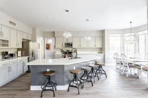 a kitchen with white cabinets and a large island with bar stools at Serenity Now in Phoenix