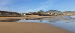 einen Sandstrand mit Bergen im Hintergrund in der Unterkunft Apartamento Pedras Pretas in Porto Santo