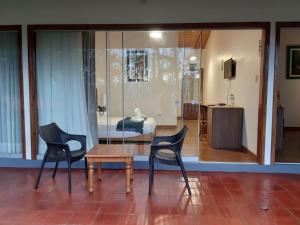 a room with two chairs and a table and a bed at La Ensenada Hotel Chachapoyas in Chachapoyas