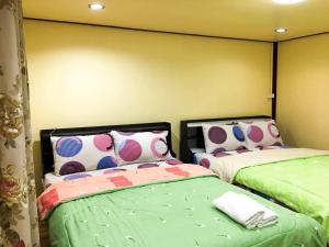 two beds sitting next to each other in a bedroom at Ruanmai Style Resort 2 in Ban Nong Nam Khan