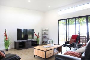 a living room with a television and a table at The Red Door @ Barossa Valley Vineyard View in Nuriootpa