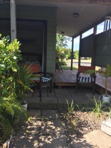 eine Veranda mit einem Bett und einer Bank darauf in der Unterkunft Studio at Matarangi in Whitianga