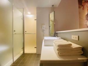 台北的住宿－Artinn藝築文旅-台北站前館，浴室配有水槽、淋浴和毛巾