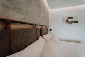 uma cama com uma cabeceira em madeira com almofadas brancas em Böden Hotel & Spa by AKEN Soul em Villa General Belgrano